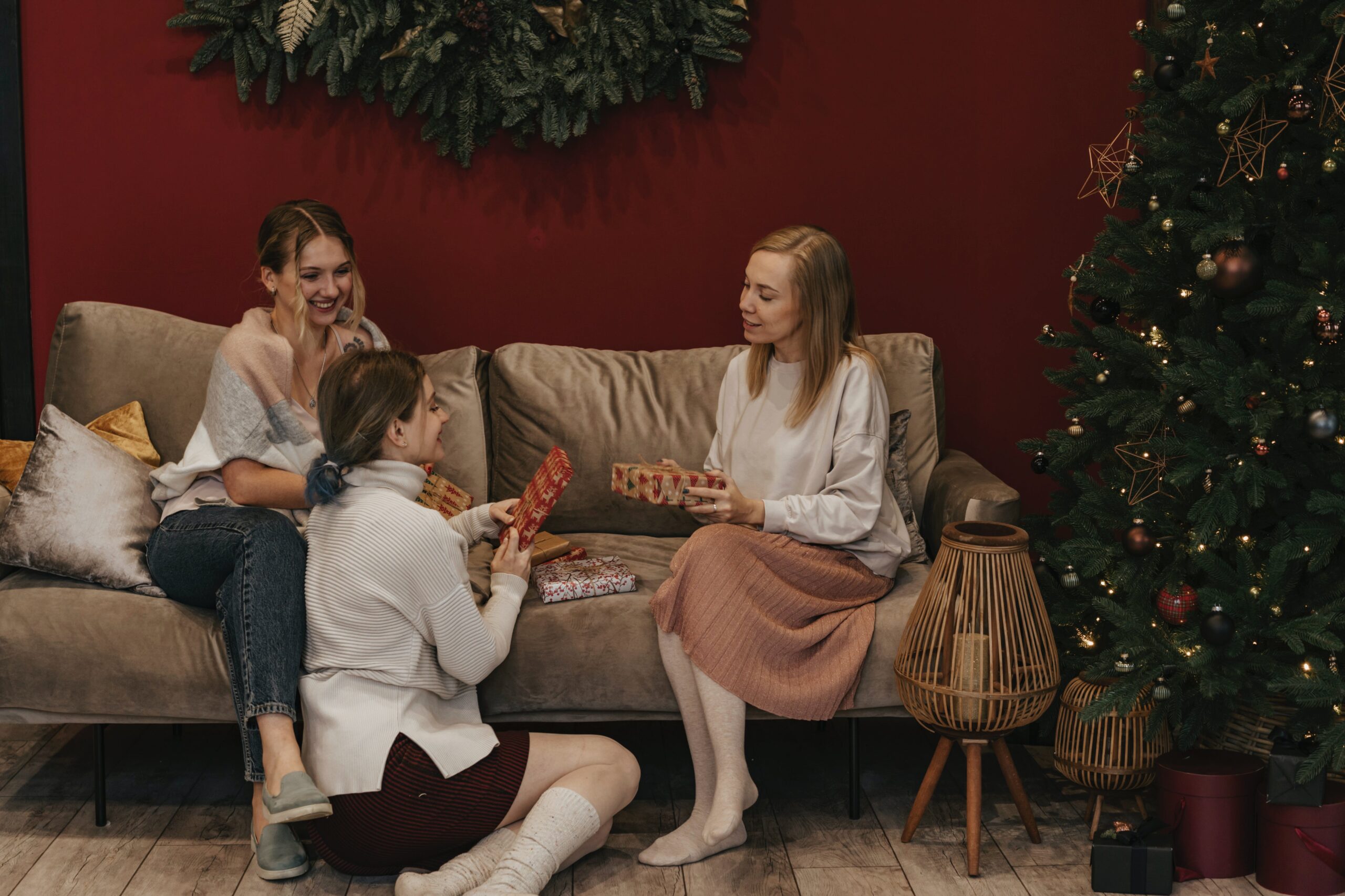 three friends sitting by a Christmas tree